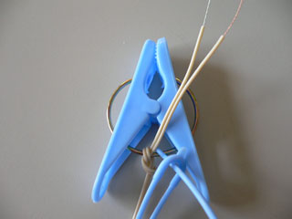 ミニプラグから出た電線のが洗濯バサミのリングに縛りつけられている写真